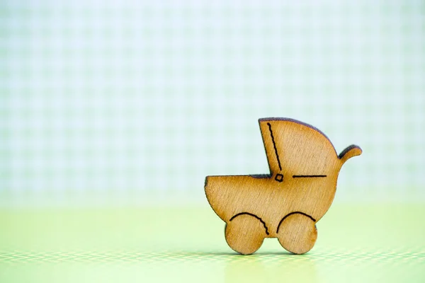 Icono de madera de bebé buggy sobre fondo a cuadros verde — Foto de Stock
