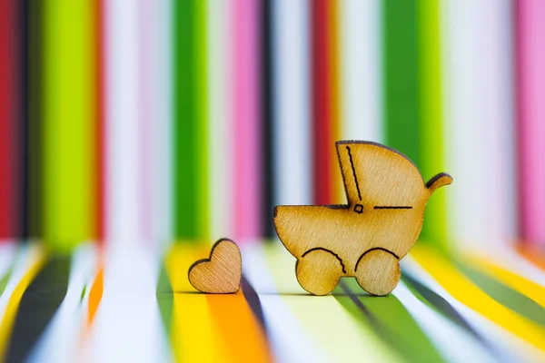 Drewniane ikony baby buggy i serduszko na kolorowe paski b — Zdjęcie stockowe