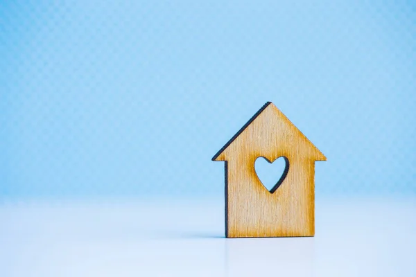 Maison en bois avec trou en forme de coeur sur fond bleu — Photo