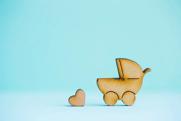 Drewniane ikony baby buggy i serduszko na tle mięty — Zdjęcie stockowe