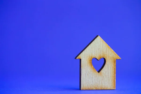 Maison en bois avec trou en forme de coeur sur fond bleu — Photo