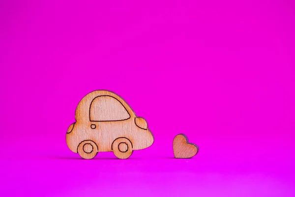Fából készült autó ikon a kis szívét, bíbor háttérben — Stock Fotó