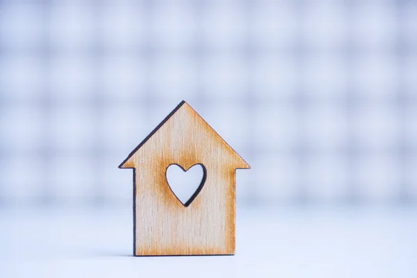 Wooden house with hole in form of heart on checkered background — Stock Photo, Image