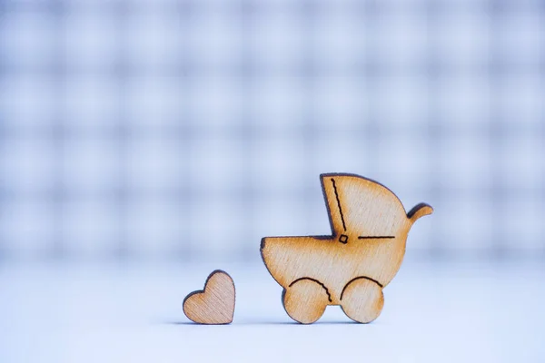 Drewniane ikony baby buggy i serduszko na kratkę backgrou — Zdjęcie stockowe