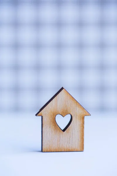 Casa de madeira com furo em forma de coração em cinza xadrez backgr — Fotografia de Stock