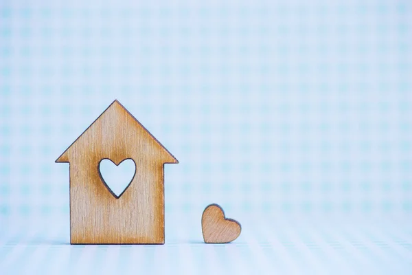 Casa de madeira com furo em forma de coração com pouco coração no blu — Fotografia de Stock