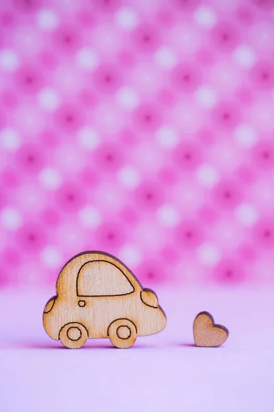 Dřevěné auto s ikonkou srdíčko na růžovém pozadí strakaté — Stock fotografie