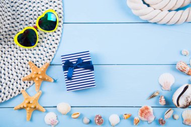 Şapka ve güneş gözlüğü kabukları, starfishes, hediye kutusu ve ip üzerinde