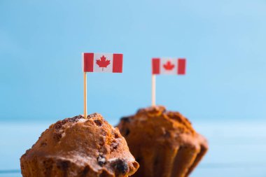 Mavi arka plan üzerinde Kanada bayrağı ile iki ev yapımı kekler