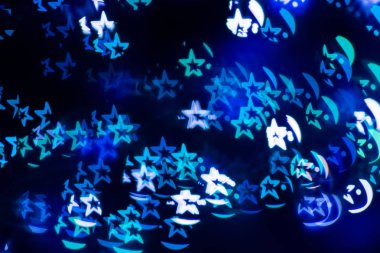 Şekli yıldız koyu zemin üzerine mavi şenlikli bokeh