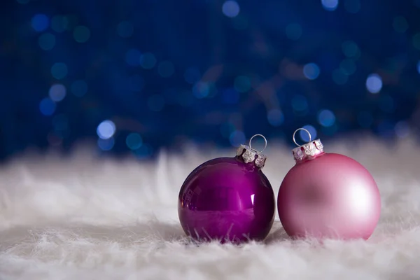 Boules de Noël violettes et roses sur fourrure blanche avec guirlande — Photo