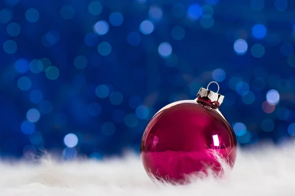 Boule de Noël Bourgogne sur fourrure blanche avec guirlande lumières sur bleu — Photo