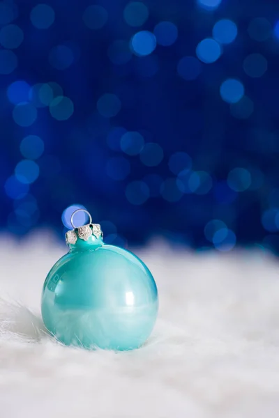 Mint Boże Narodzenie ball na białe futro z garland światła na bok niebieski — Zdjęcie stockowe