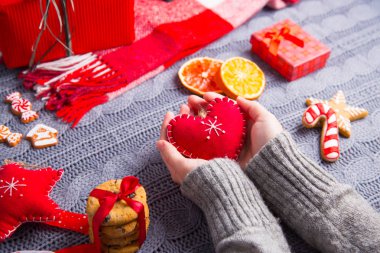 Gri örgü kazaklı İsa kırmızı kalp tutan eller