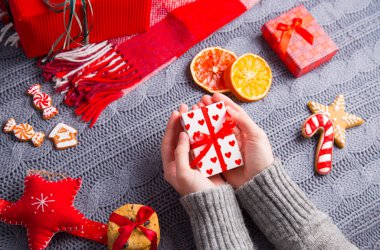 Gri örgü kazaklı hediye kutusu Christm üzerinde tutan eller