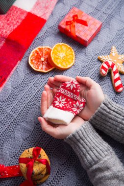 Gri örgü kazaklı küçük mitten Ch üzerinde tutan eller