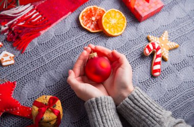 İçinde gri örgü kazak d Noel top tutan eller