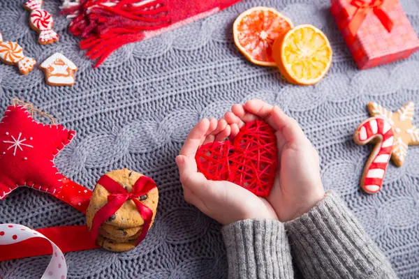 Gri örgü kazaklı İsa kırmızı kalp tutan eller