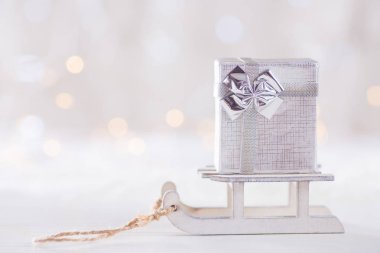 Oyuncak beyaz ışık bokeh backgrou kızağa üzerinde küçük güzel hediye kutusu