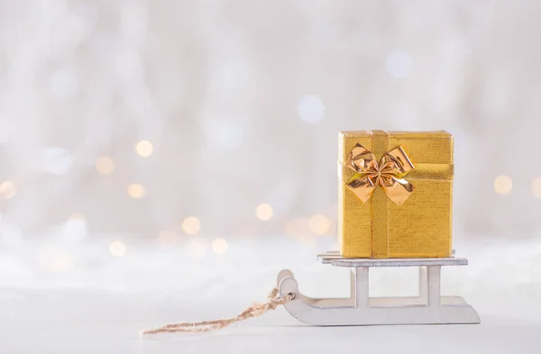 Oyuncak beyaz ışık bokeh backgrou kızağa üzerinde küçük güzel hediye kutusu