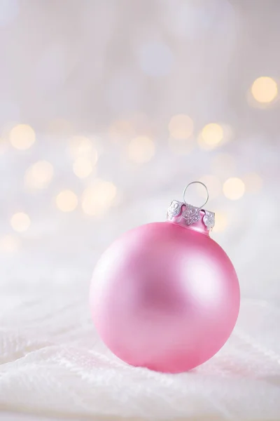 Boule de Noël rose sur dentelle blanche sur bokeh backgr clair et chaud — Photo