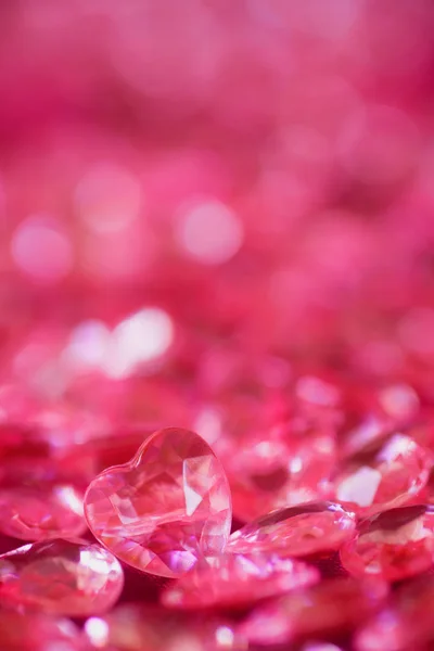 Muchos pequeños corazones rojos de cristal con fondo bokeh . —  Fotos de Stock