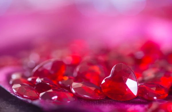 Many red little crystal hearts with bokeh background. — Stock Photo, Image