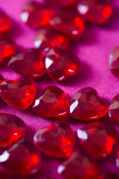 Muchos pequeños corazones rojos de cristal con fondo bokeh . — Foto de Stock