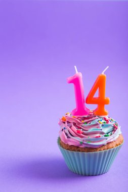 Sprinkles ve mum şeklinde şenlikli kremalı cupcake