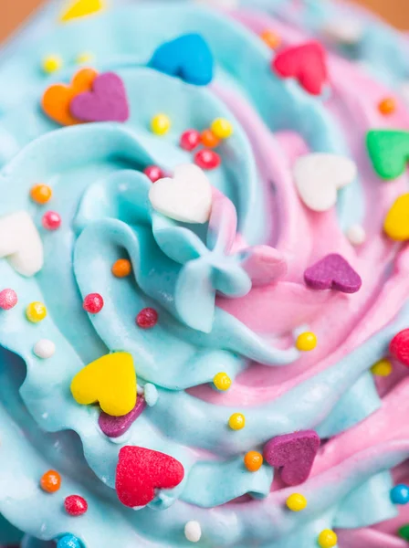 Primeros planos cupcake cremoso multicolor superior con corazones coloridos y — Foto de Stock