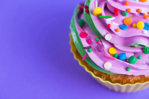 Closeup cupcake creamy multicolored top with colorful sprinkles — Stock Photo, Image