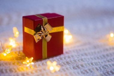 Kırmızı hediye kutusu beyaz örme adam sıcak garland ışıkları ile