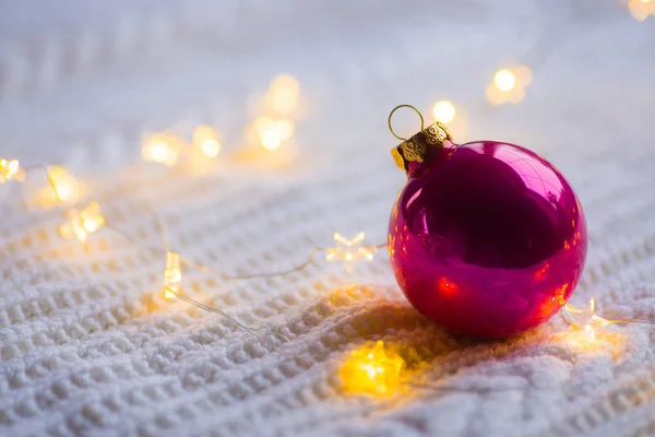 深红色圣诞球与温暖的花环灯白色针织 — 图库照片