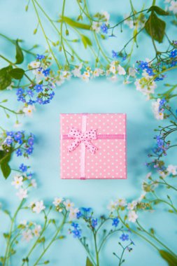 L ile ilgili küçük çiçekli mavi ve beyaz çevrili pembe hediye kutusu