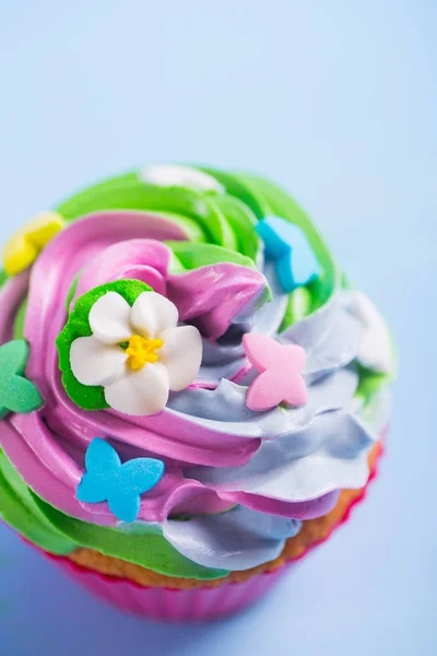 Closeup cupcake creamy multicolored top with colorful flowers an — Stock Photo, Image