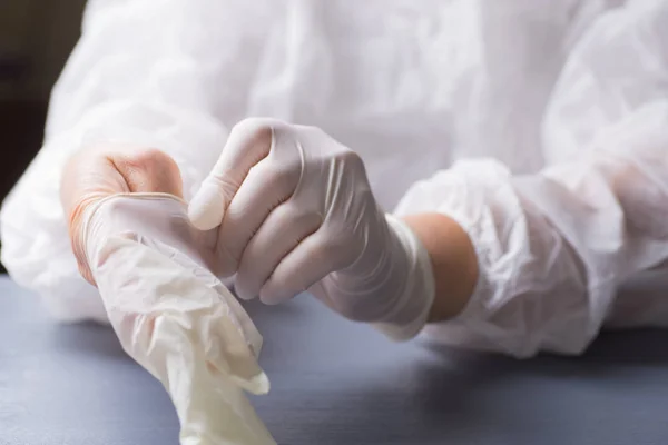Chirurg umieszcza lateksowe rękawice na jego ramieniu. Przygotowania ręce do zabiegu — Zdjęcie stockowe