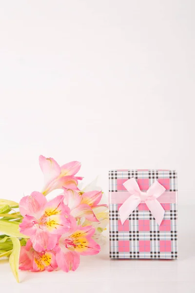Coffret cadeau rose avec bouquet tendre de belles fleurs alstroemeria sur fond blanc en bois — Photo