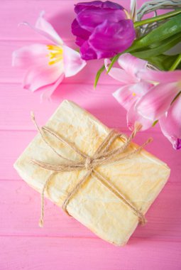 Hediye kutusu ve güzel Pembe Lale pembe ahşap zemin üzerine ihale buket hazırlanmış