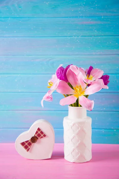 Coffret cadeau en forme de coeur et bouquet tendre de belles tulipes roses en vase blanc sur fond de bois bleu et rose — Photo