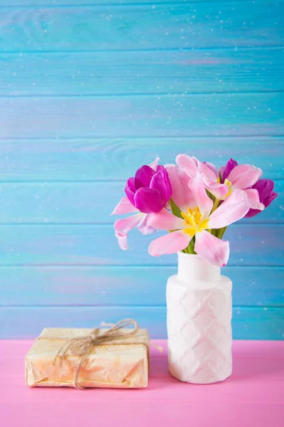Coffret cadeau artisanal et bouquet tendre de belles tulipes roses dans un vase sur fond de bois bleu et rose — Photo