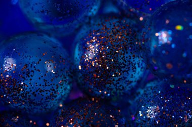 Kapalı mavi şeffaf toplar seçici odaklı bakır pullar serpiştirilmiş. Kopya alanı ile soyut desenli arkaplan.