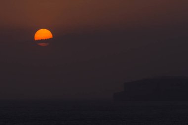 Deniz manzarasında turuncu ay