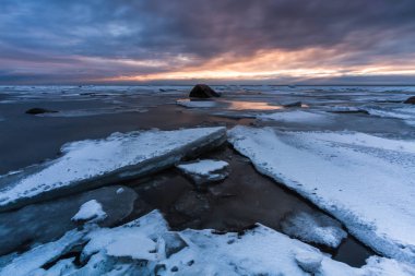 Kış deniz kıyısında gün batımında
