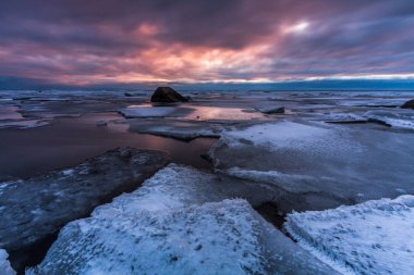 Kış deniz kıyısında gün batımında