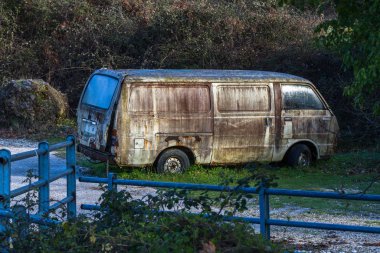 Yol kenarında eski paslı bir araba.