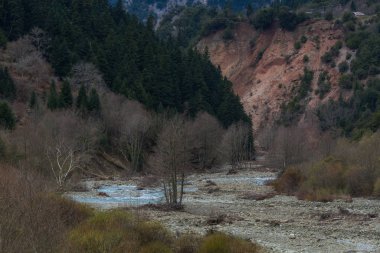 Nehir ve tepelerle kaplı dağ manzarası