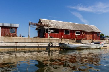 Güneşli bir günde nehir kıyısında bir tekne.