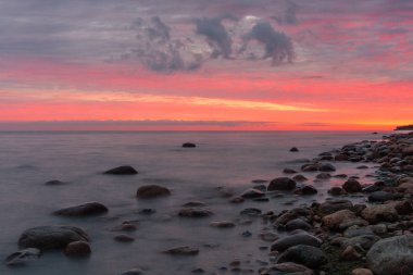 Gün batımında taş deniz kıyısında