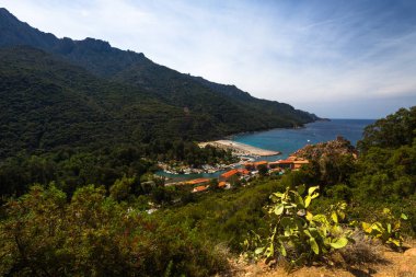 Kayalık dağlar arasındaki deniz koyunda bir şehir.