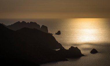 Gün batımında kayalık deniz kıyısı